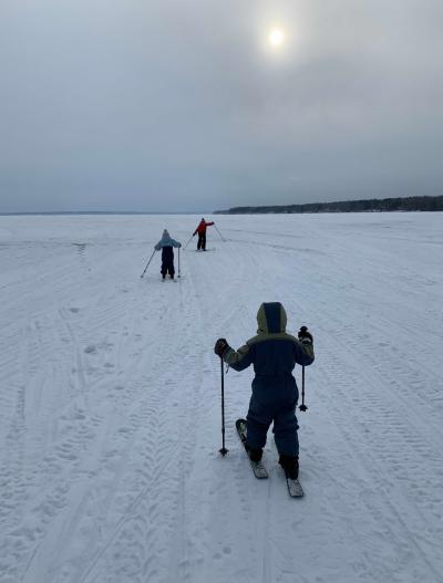 Child cross country skiing on a frozen lake